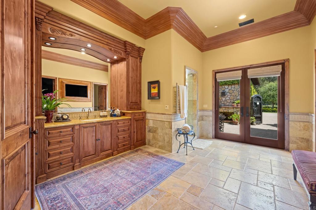 6314 El Apajo Rancho Santa Fe, CA 92067 - Photo 38 of 60 a large bathroom with a double vanity sink a large mirror and a bathtub