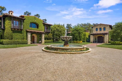 a view of a house with a big yard and large trees