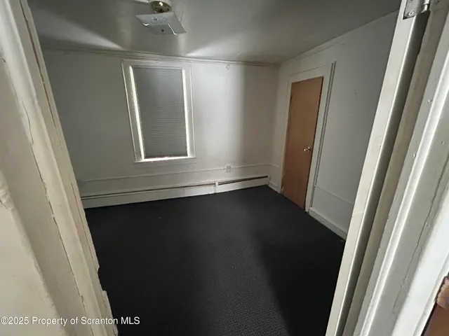 a view of a small space with wooden floor and a window