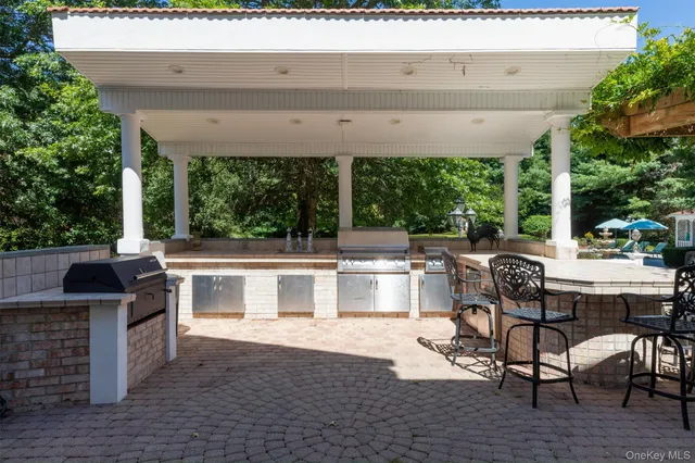 a view of a patio with table and chairs a barbeque with wooden fence