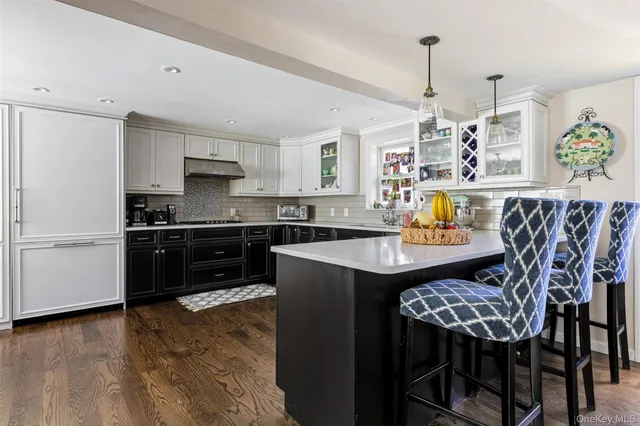 a kitchen with a table chairs microwave and cabinets