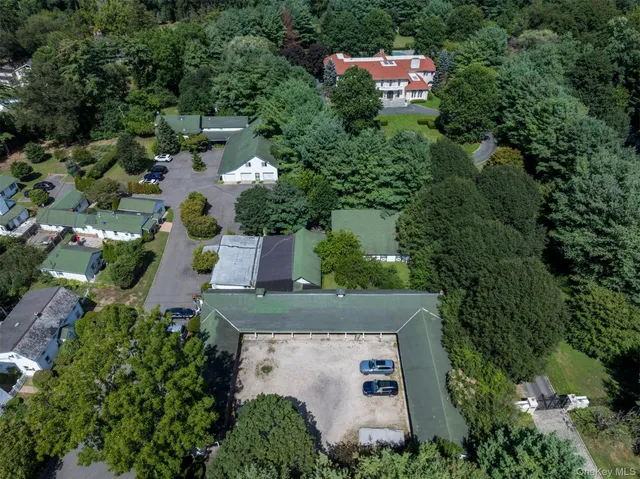 an aerial view of a house with a yard and trees all around