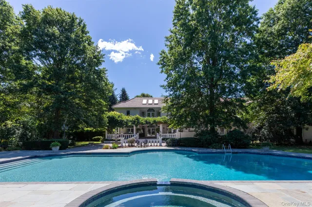a view of a swimming pool with lawn chairs under an umbrella