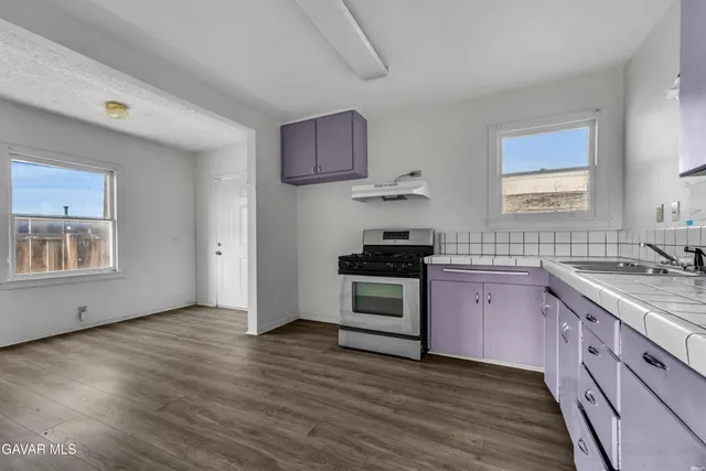 a kitchen with a sink stove and cabinets