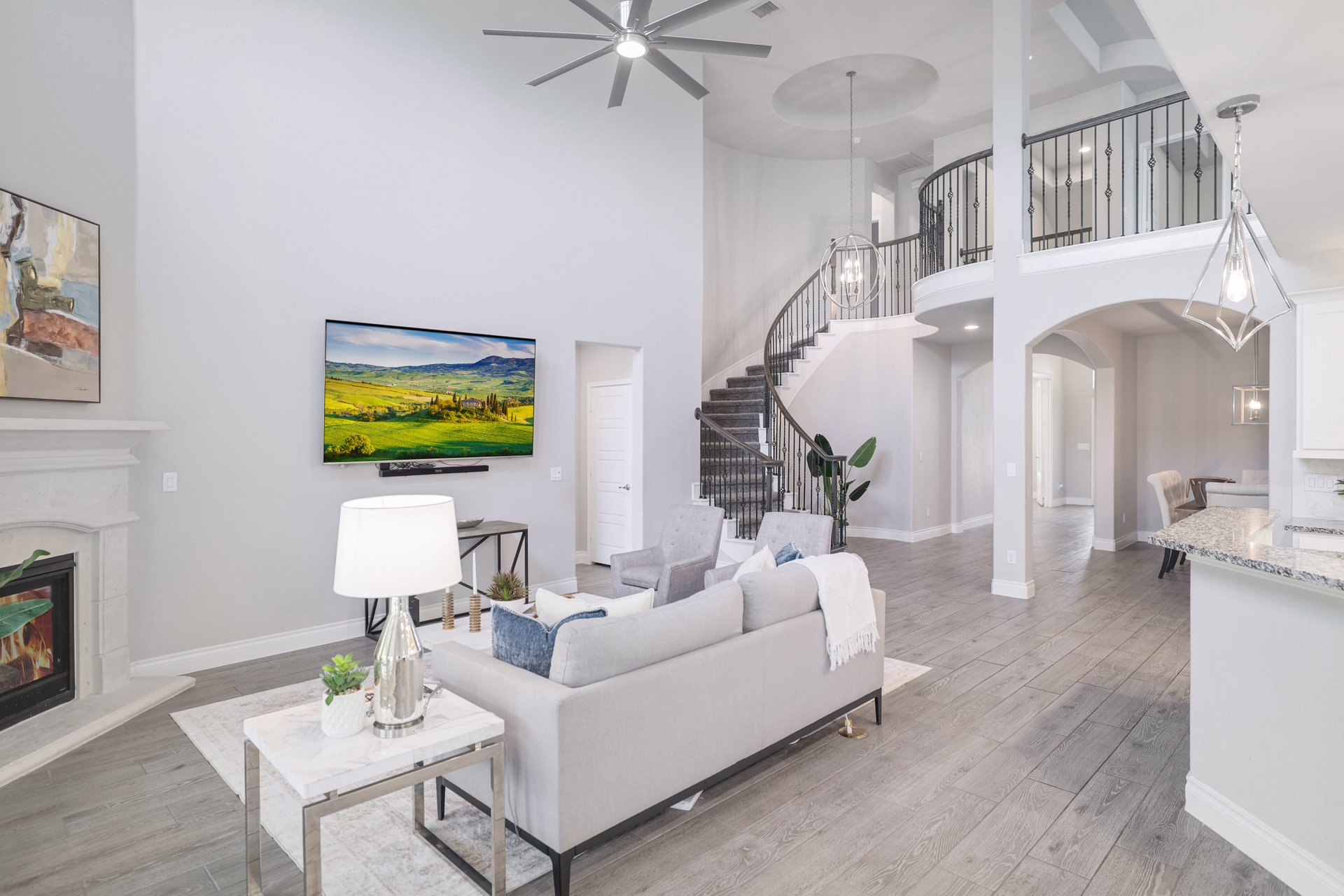 1513 Lakeside Ranch Road Georgetown, TX 78633 - Photo 11 of 40 Living room with a glass covered fireplace, light wood-style floors, ceiling fan, a high ceiling, and arched walkways