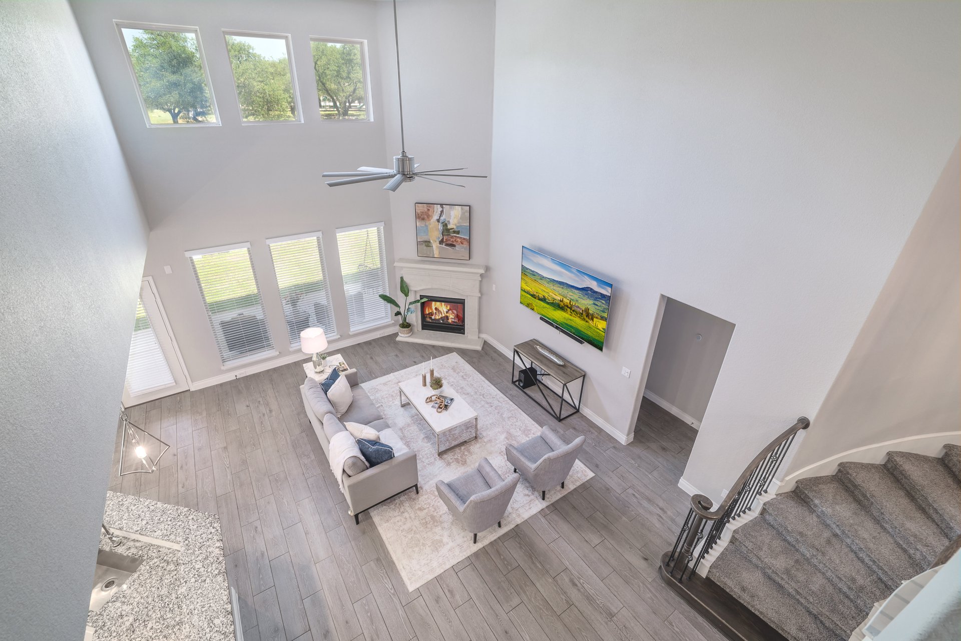 1513 Lakeside Ranch Road Georgetown, TX 78633 - Photo 12 of 40 Living area with plenty of natural light, a high ceiling, wood finished floors, a glass covered fireplace, and ceiling fan