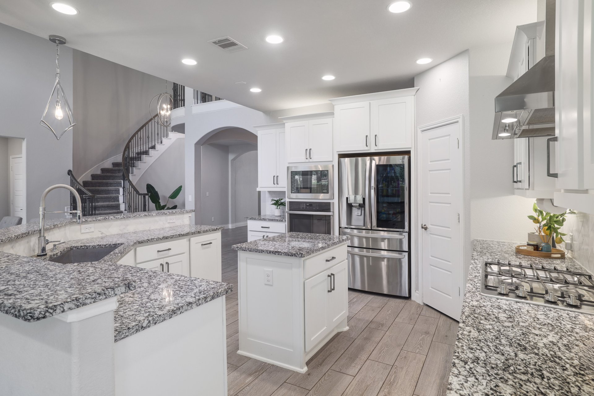 1513 Lakeside Ranch Road Georgetown, TX 78633 - Photo 15 of 40 Kitchen featuring white cabinets, pendant lighting, stainless steel appliances, wood tiled floors, and light stone countertops
