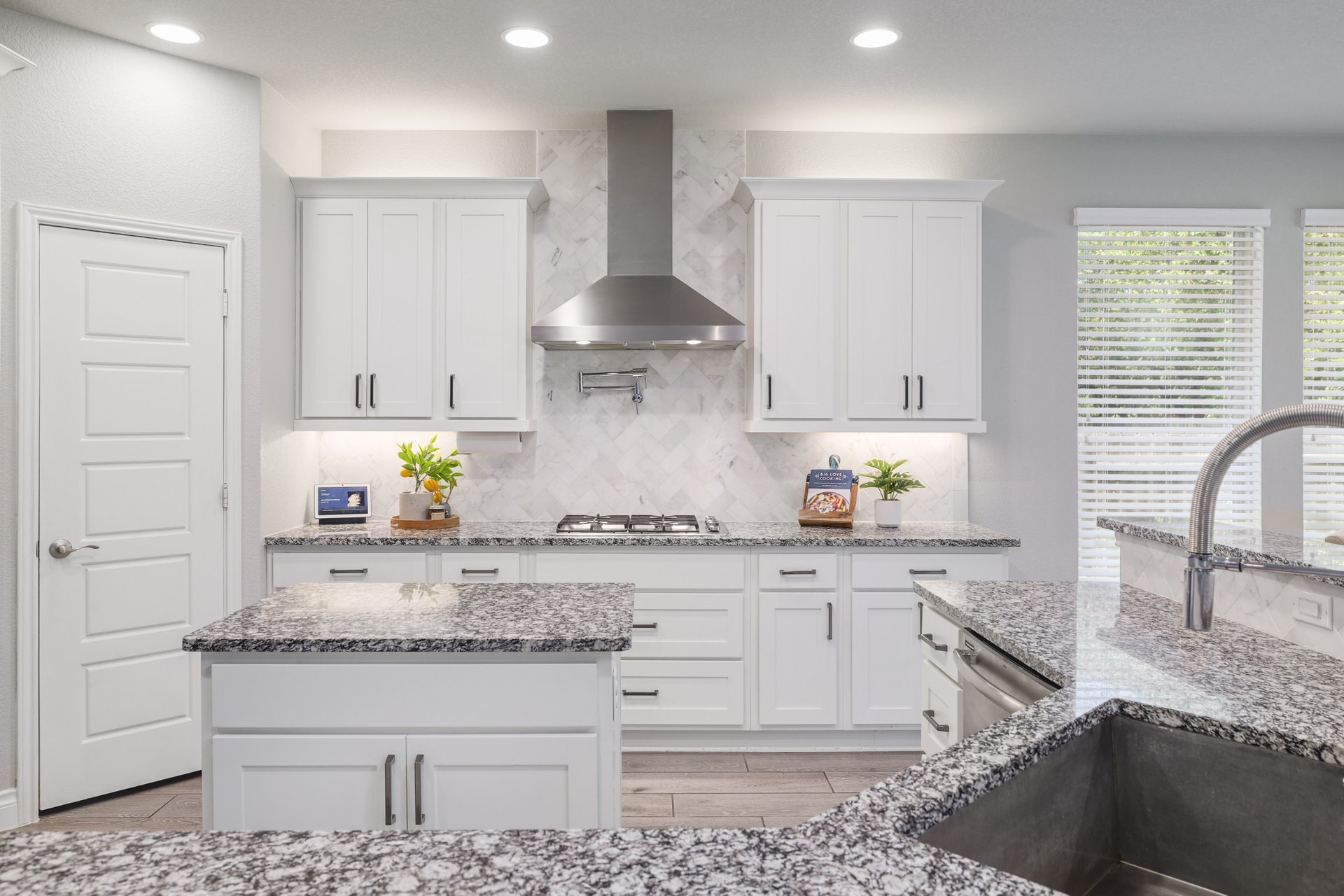 1513 Lakeside Ranch Road Georgetown, TX 78633 - Photo 17 of 40 Kitchen with white cabinets, light stone counters, light wood-style floors, and recessed lighting
