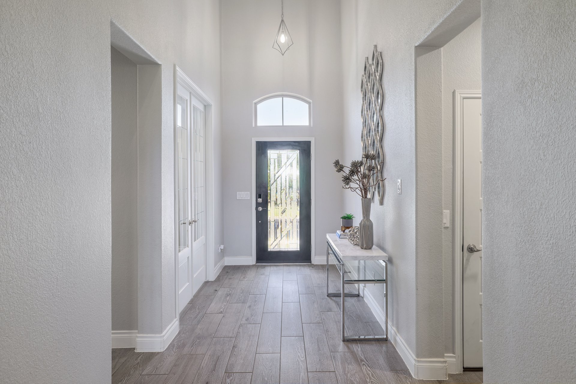 1513 Lakeside Ranch Road Georgetown, TX 78633 - Photo 22 of 40 Entrance foyer with a textured wall, a high ceiling, and light wood-style floors