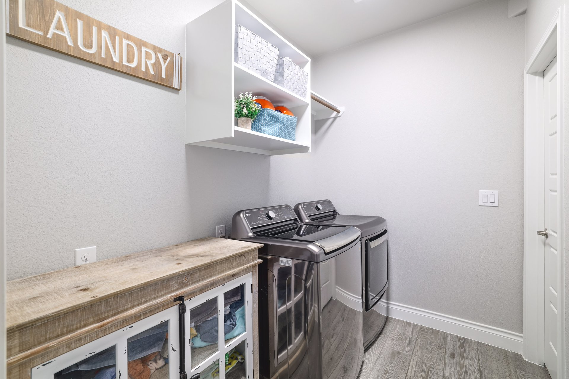 1513 Lakeside Ranch Road Georgetown, TX 78633 - Photo 30 of 40 Laundry area with light wood-style floors, washing machine and clothes dryer, and a textured wall