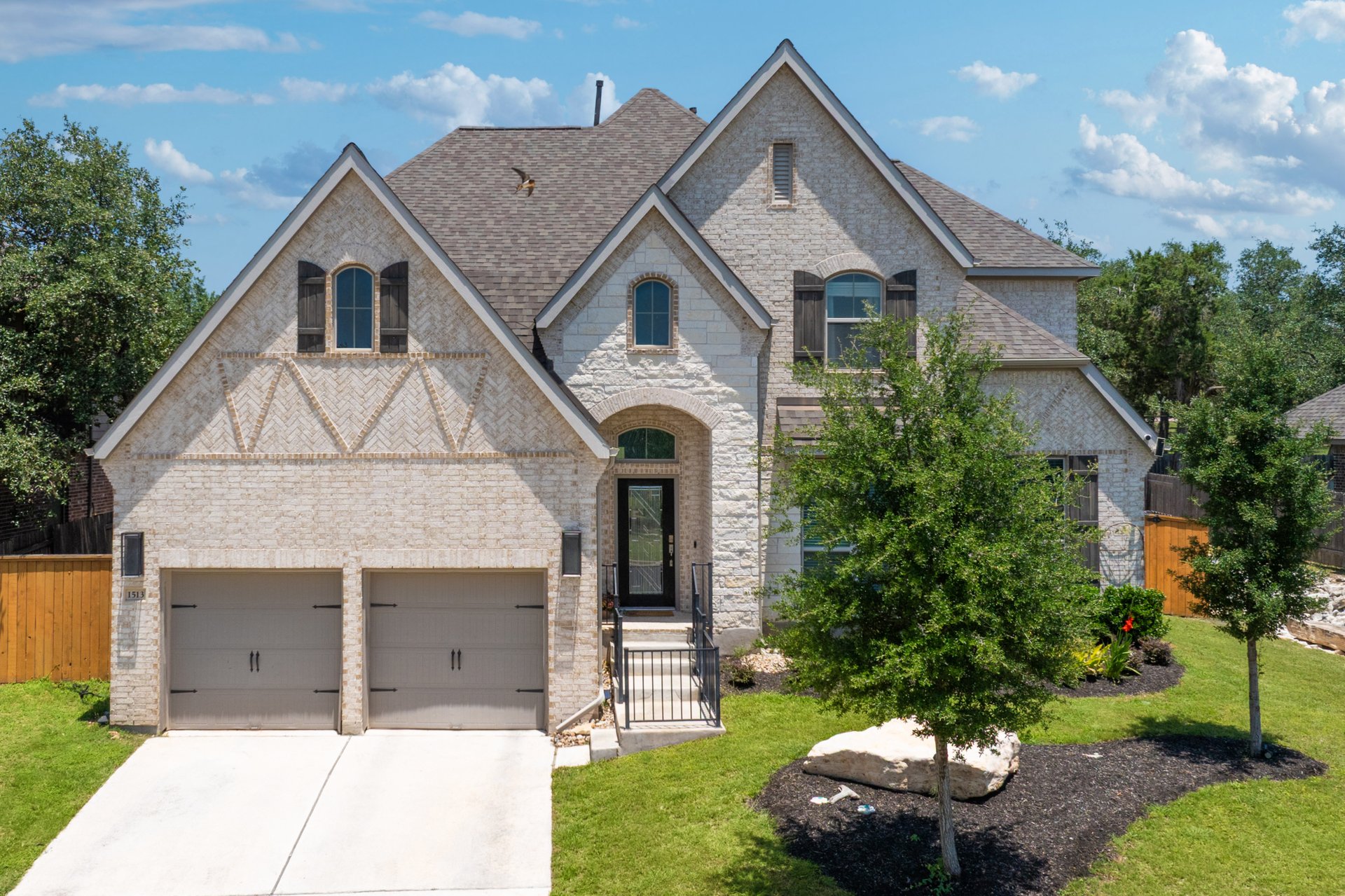 1513 Lakeside Ranch Road Georgetown, TX 78633 - Photo 3 of 40 French country inspired facade with brick siding, driveway, roof with shingles, and stone siding