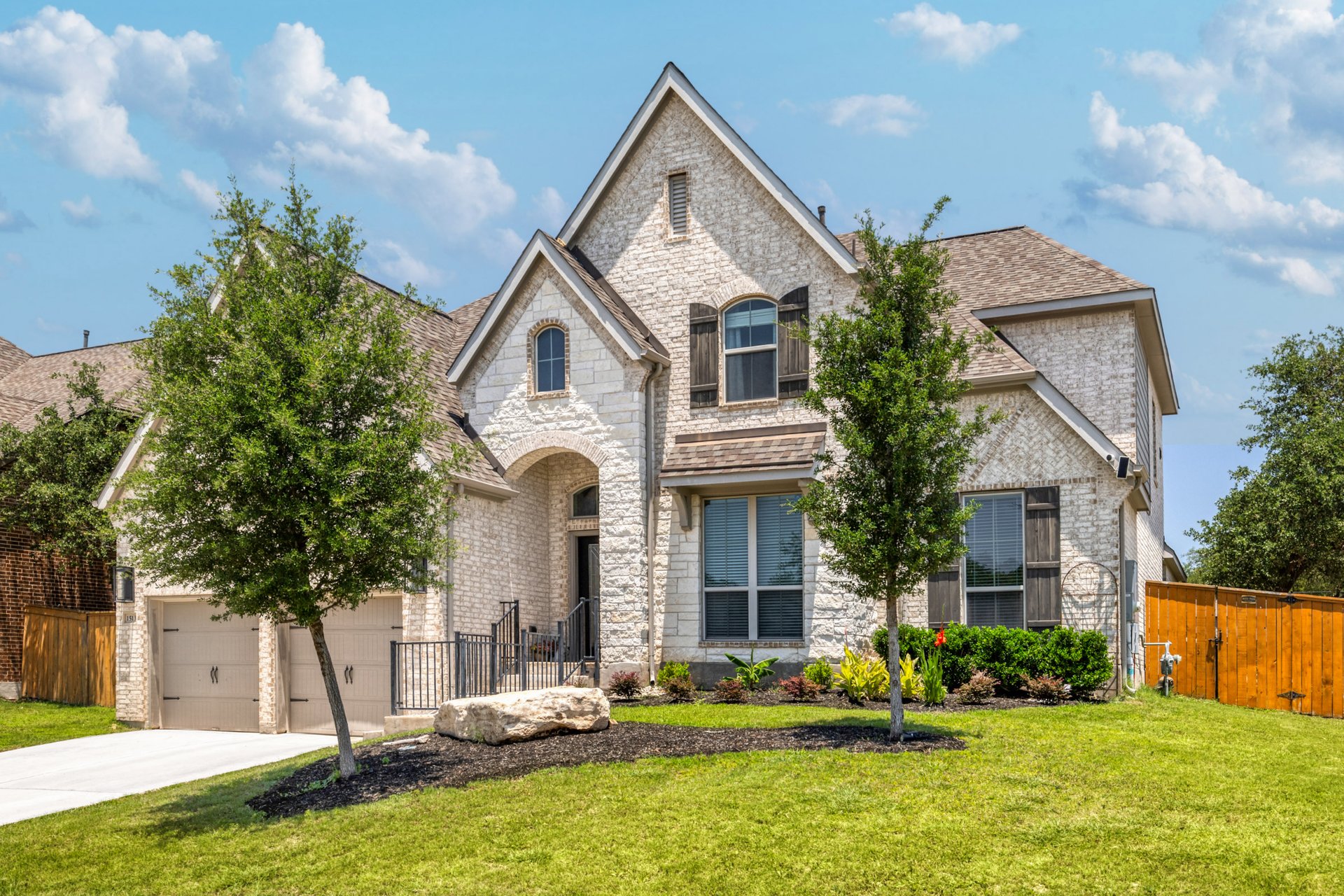 1513 Lakeside Ranch Road Georgetown, TX 78633 - Photo 4 of 40 French country inspired facade featuring stone siding, a garage, driveway, and brick siding
