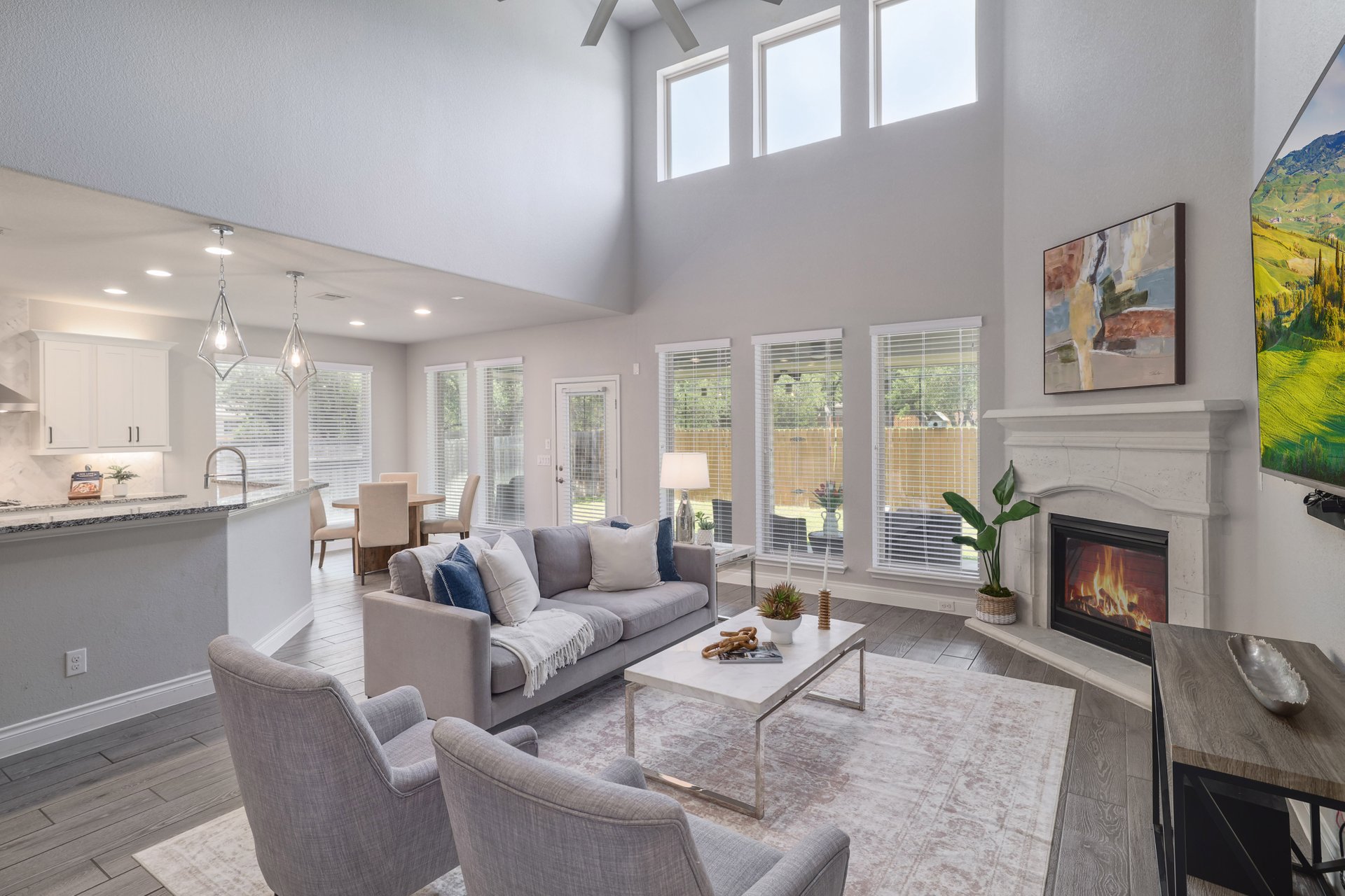 1513 Lakeside Ranch Road Georgetown, TX 78633 - Photo 8 of 40 Living room featuring a glass covered fireplace, light wood-style flooring, healthy amount of natural light, and a ceiling fan