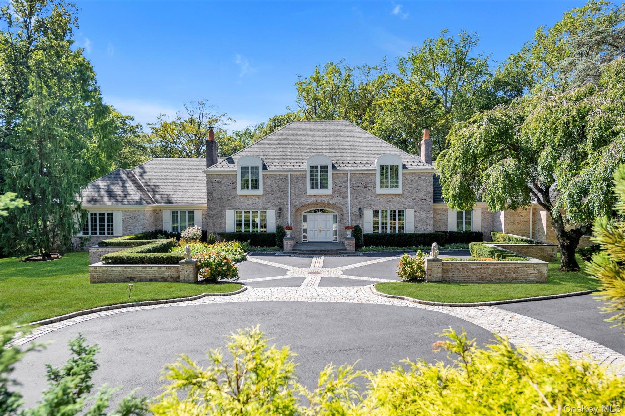 12 Overlook Court Locust Valley, NY 11560 - Photo 3 of 49 a front view of a house with a garden
