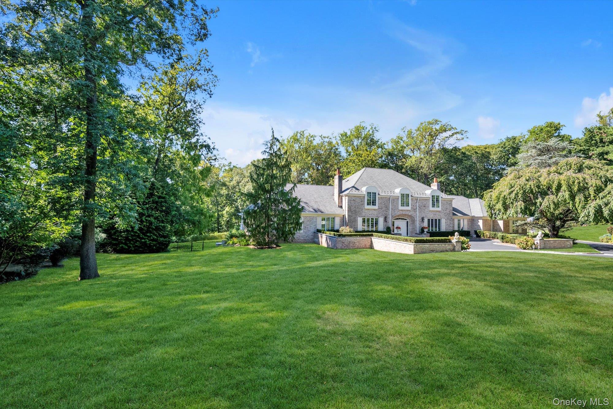 12 Overlook Court Locust Valley, NY 11560 - Photo 4 of 49 a view of a big house with a big yard and large trees