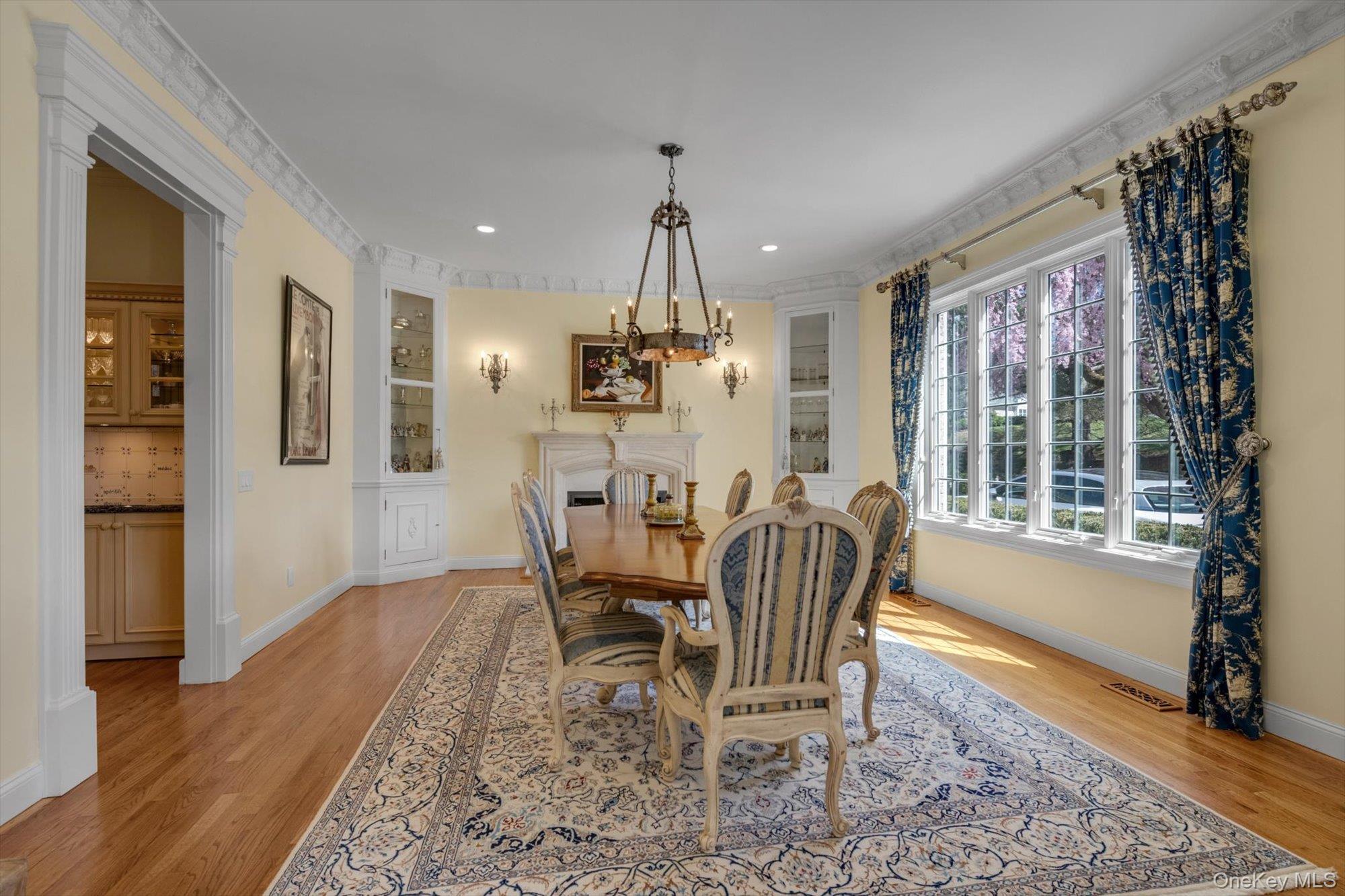 12 Overlook Court Locust Valley, NY 11560 - Photo 10 of 49 a dining room with wooden floor a chandelier a wooden table and chairs