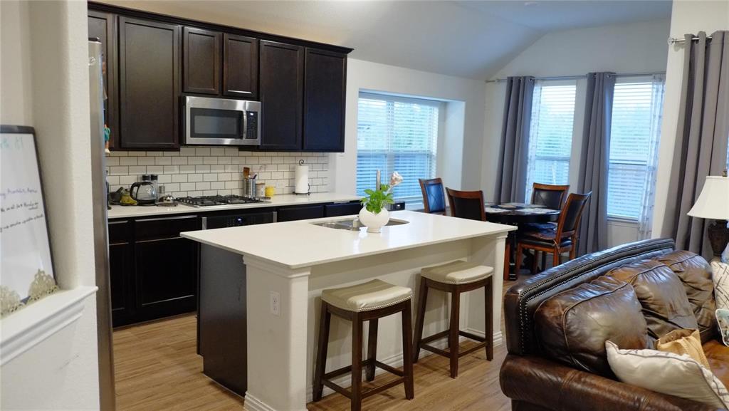 1907 Edgecreek Path Lewisville, TX 75010 - Photo 7 of 10 a kitchen with a sink a microwave a stove and refrigerator