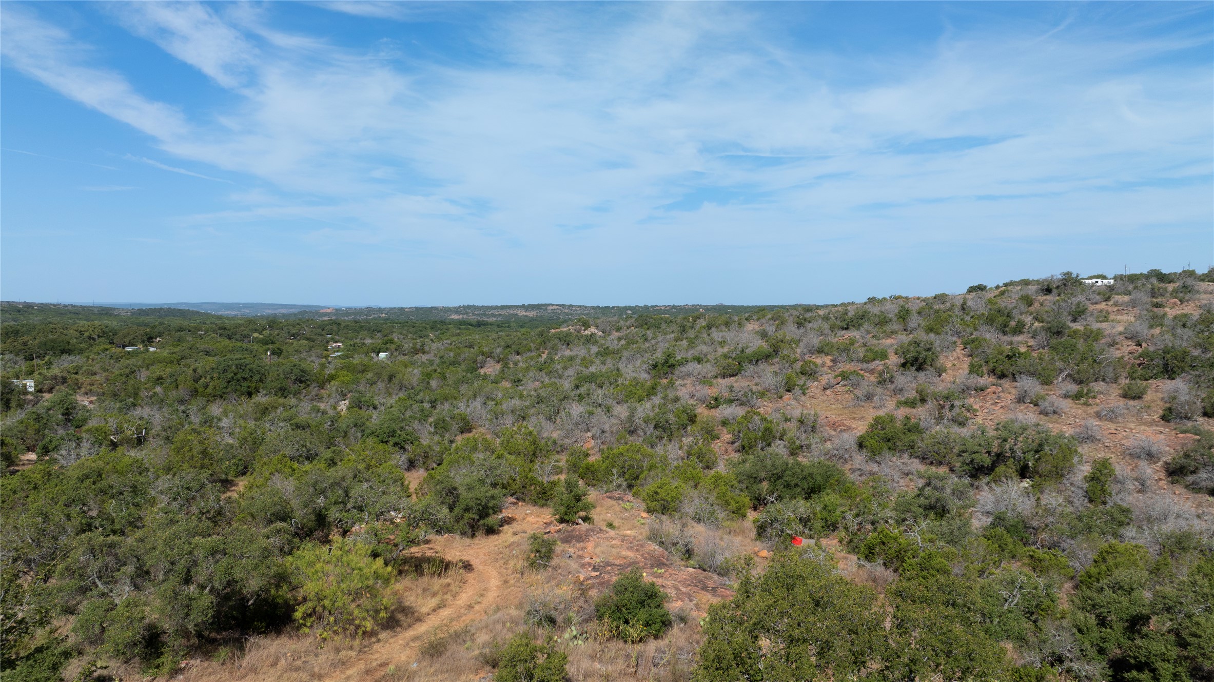 222 Valley Drive Burnet, TX 78611 - Photo 3 of 5 Rolling hillsides and dense native tree canopies frame this expansive countryside landscape.