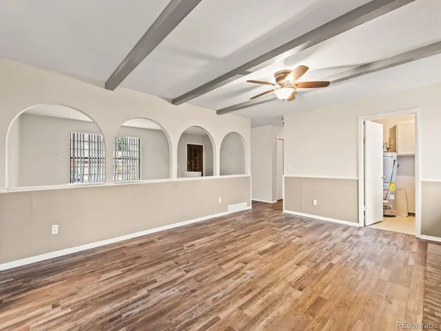 a kitchen with a refrigerator white stove a sink and a oven with wooden floor