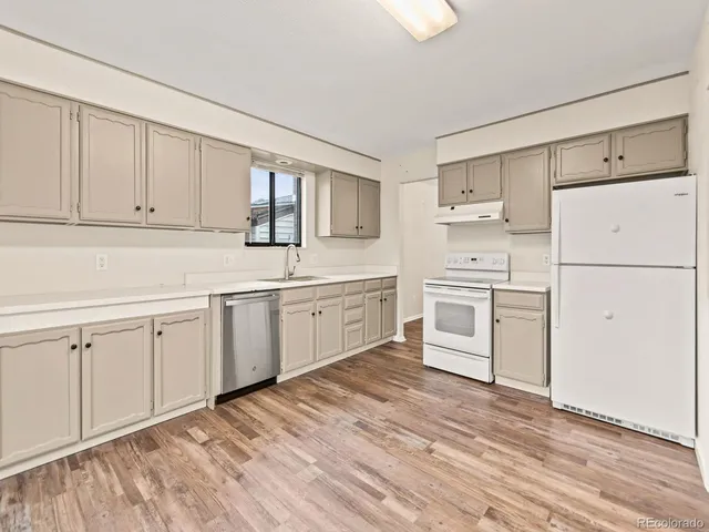 a kitchen with stainless steel appliances cabinets a sink and a large window