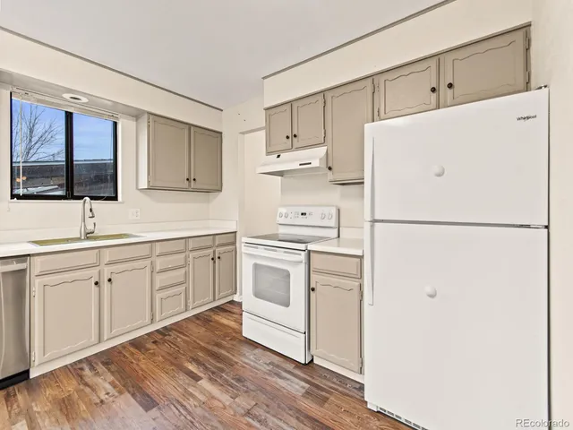 a kitchen with white cabinets and white appliances