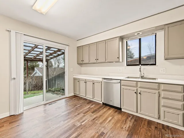 a kitchen with granite countertop a sink and dishwasher with cabinets