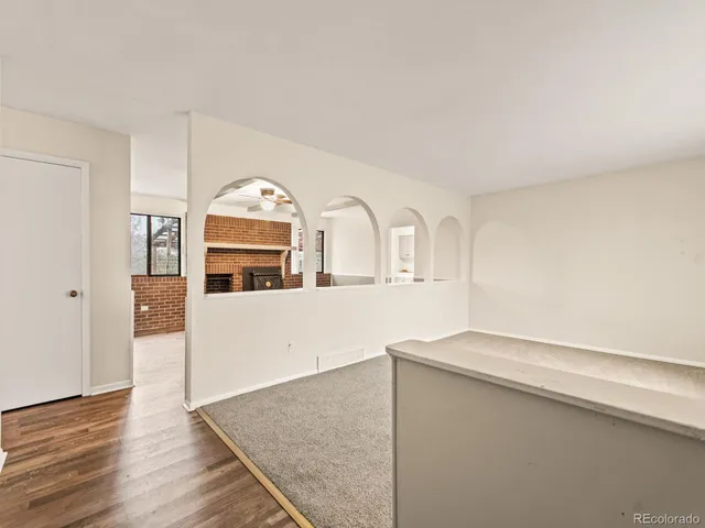 wooden floor fireplace and windows in an empty room