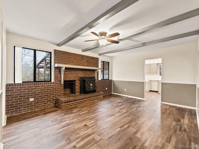 an empty room with windows and fireplace