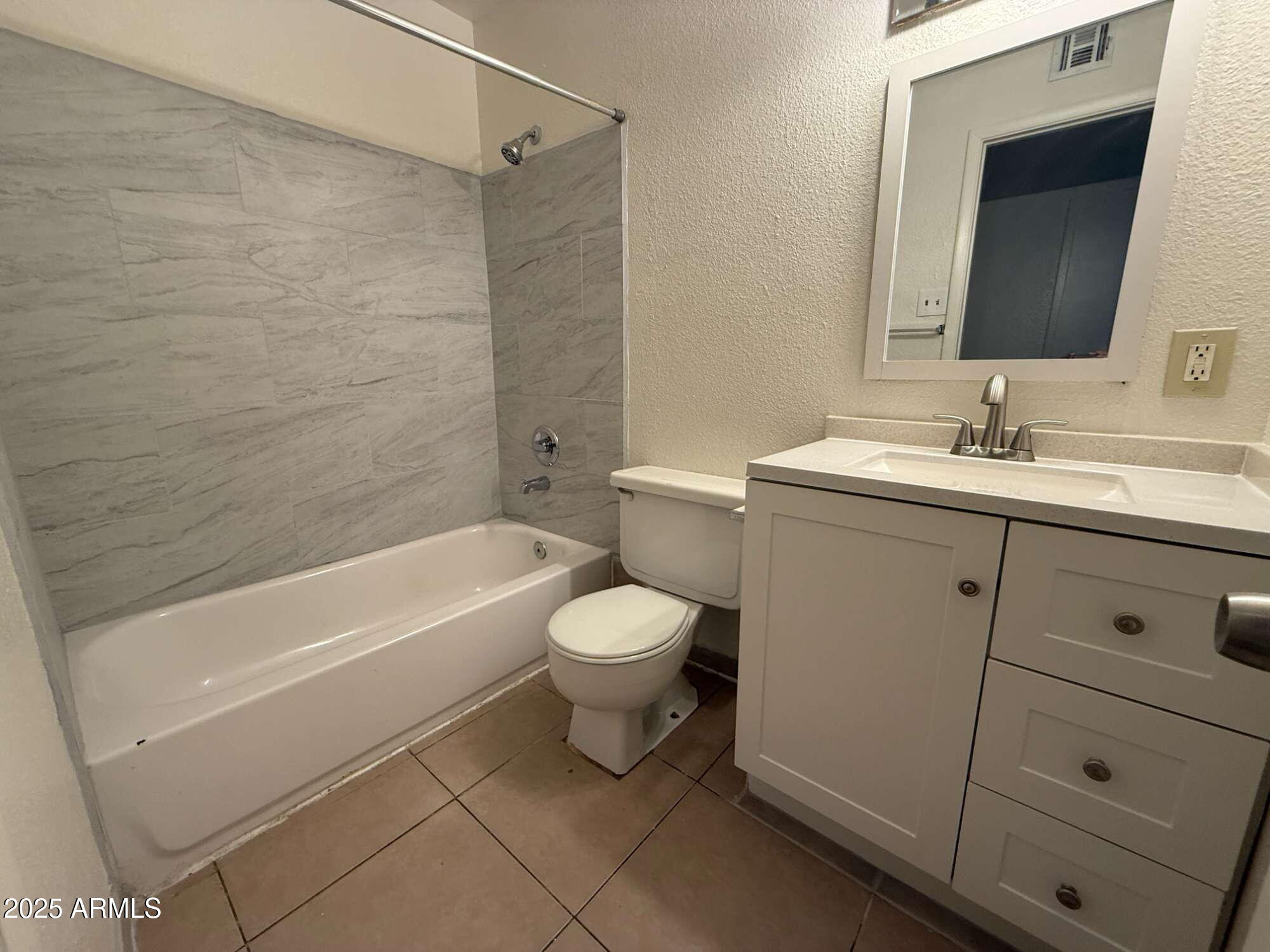 3947 West Wonderview Road Phoenix, AZ 85019 - Photo 9 of 16 a bathroom with a toilet a sink a mirror and bathtub