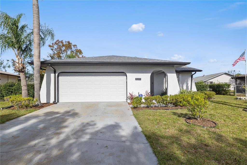 8209 Rugby Court Hudson, FL 34667 - Photo 1 of 1 a front view of a house with a yard and garage