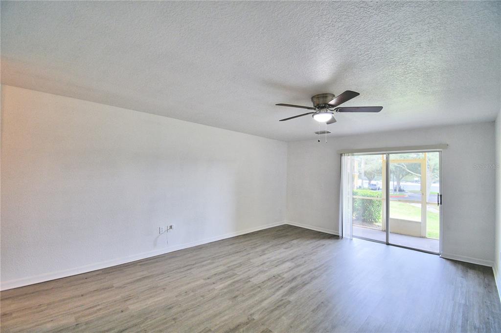 5359 River Rock Road Lakeland, FL 33809 - Photo 20 of 51 an empty room with wooden floor fan and windows