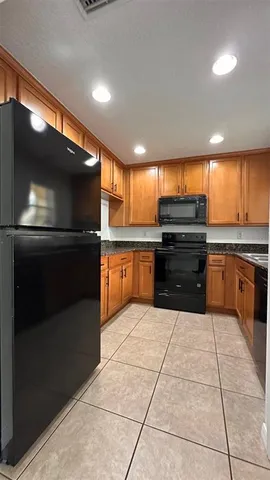 a kitchen with granite countertop a sink stove and refrigerator