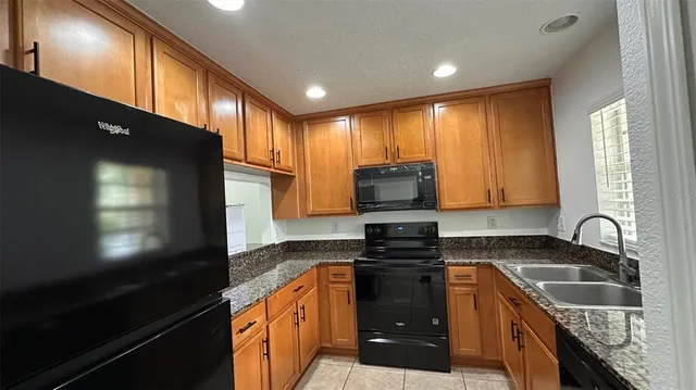 a kitchen with stainless steel appliances a stove microwave and sink