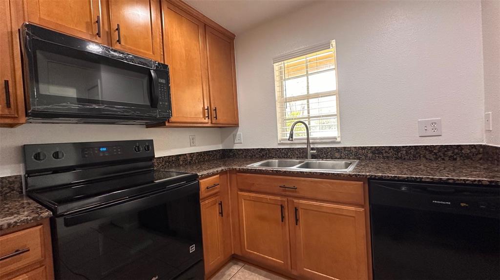 5359 River Rock Road Lakeland, FL 33809 - Photo 7 of 51 a kitchen with stainless steel appliances a stove microwave and sink