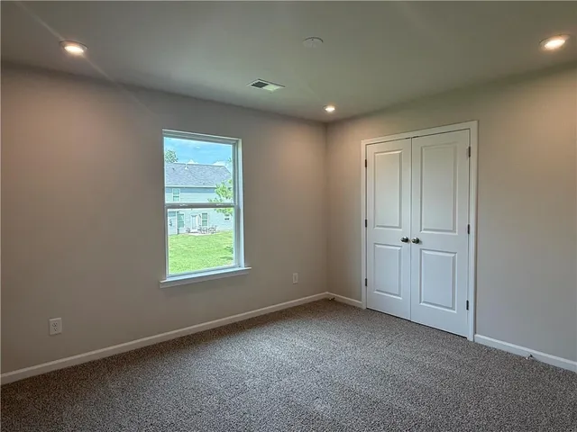 an empty room with windows and closet