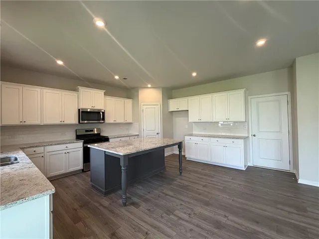 a kitchen with a sink cabinets and wooden floor