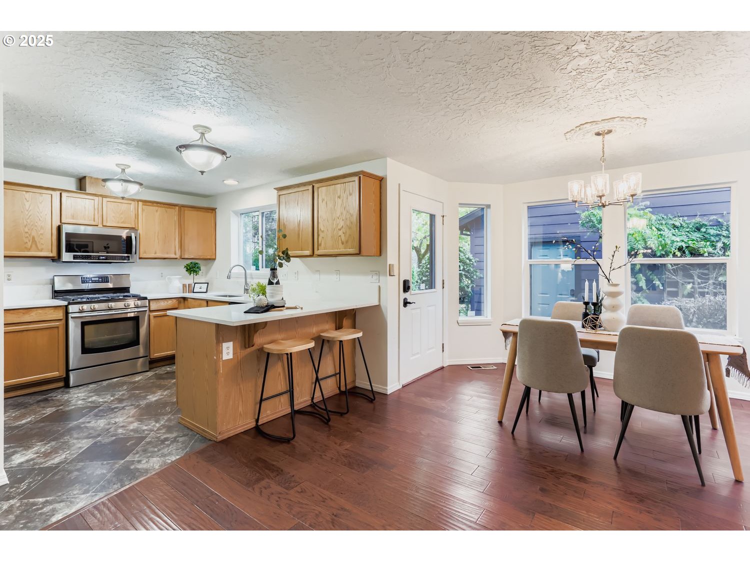 5626 North Williams Avenue Portland, OR 97217 - Photo 5 of 21 a kitchen with stainless steel appliances granite countertop a stove top oven a sink a dining table and chairs
