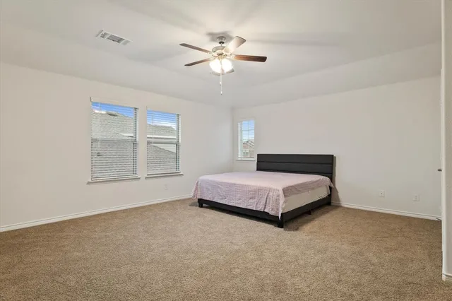 a spacious bedroom with a bed and window