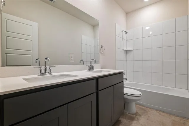 a bathroom with a double vanity sink toilet and shower