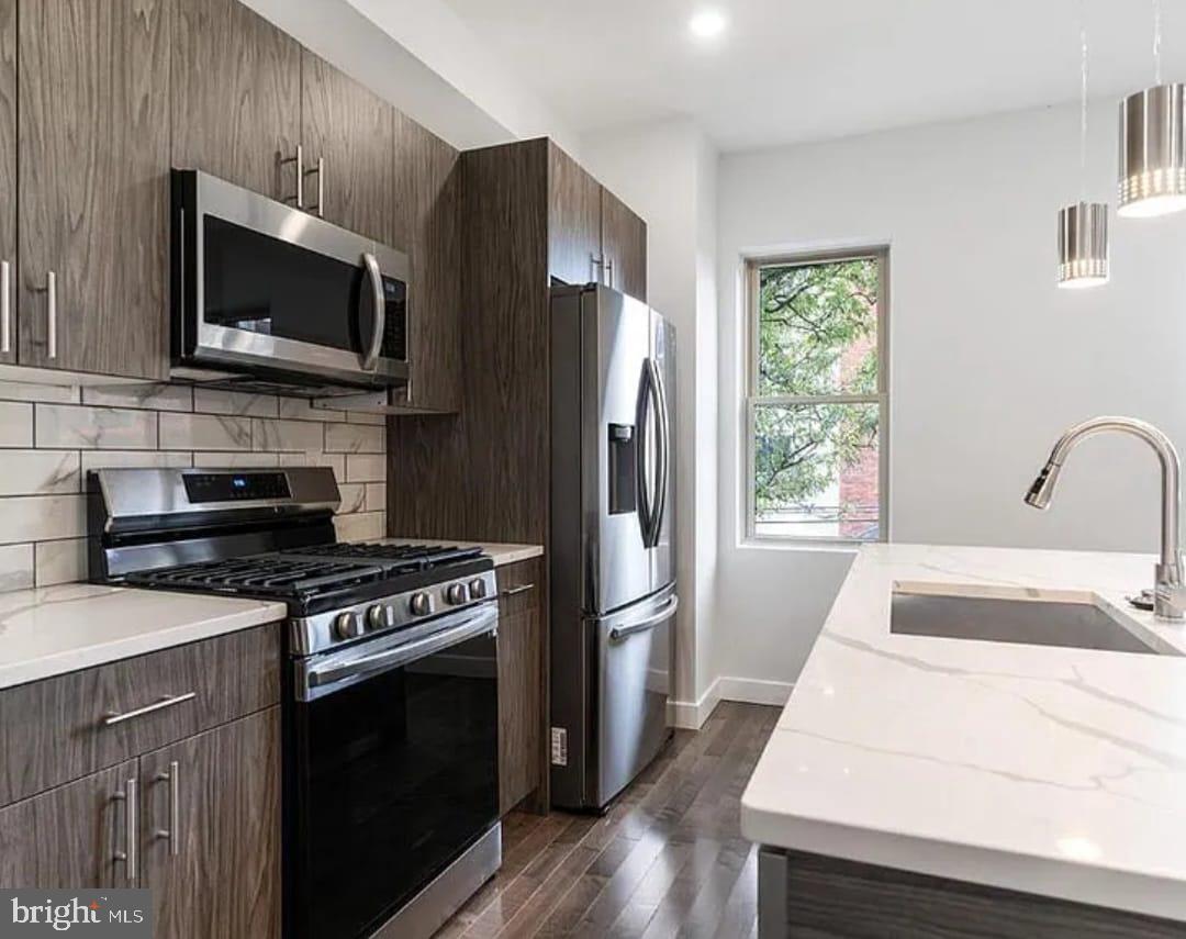 1945 North 7th Street, Unit 3 Philadelphia, PA 19122 - Photo 1 of 22 a kitchen with a stove a microwave and a refrigerator