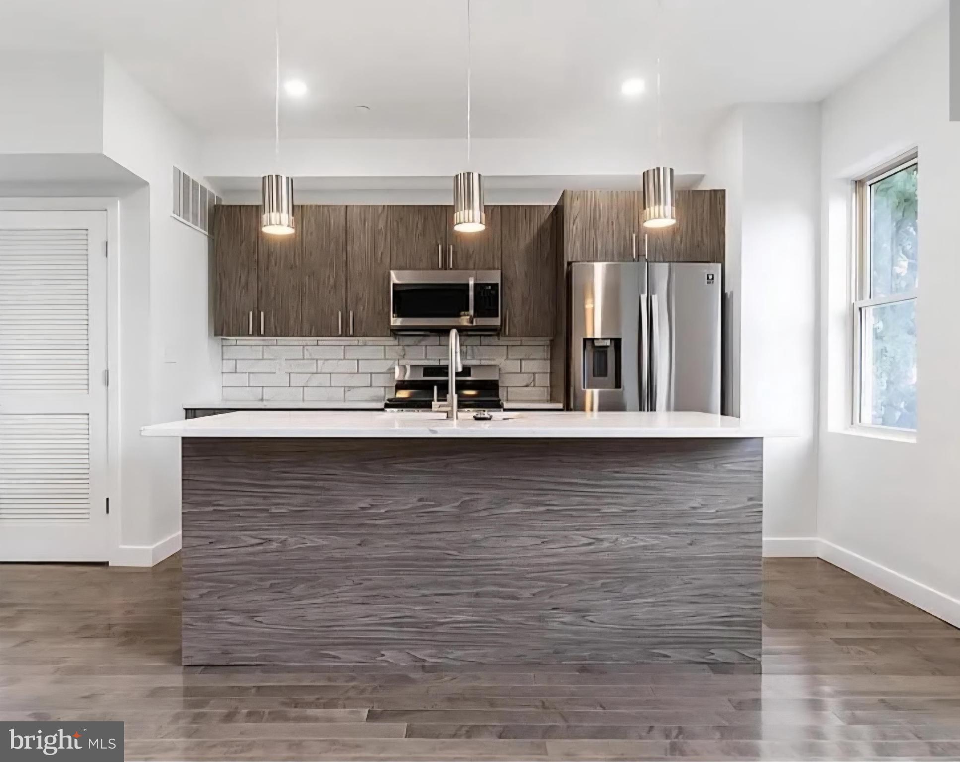 1945 North 7th Street, Unit 3 Philadelphia, PA 19122 - Photo 3 of 22 a kitchen with stainless steel appliances wooden cabinets and a counter top space
