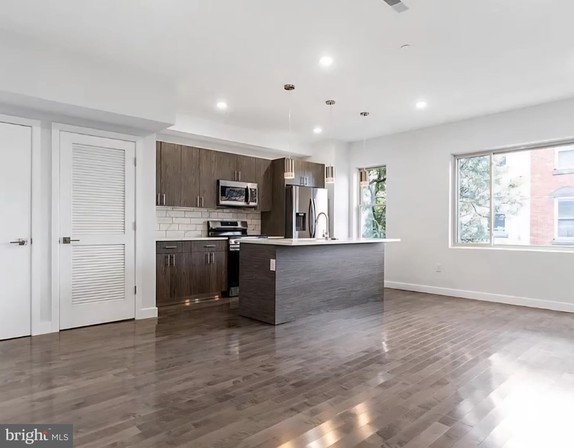 1945 North 7th Street, Unit 3 Philadelphia, PA 19122 - Photo 4 of 22 a view of kitchen with kitchen island microwave and wooden floor