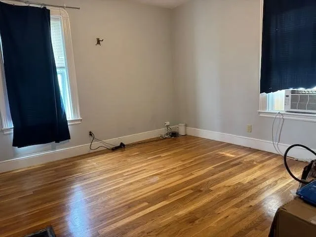 a view of a room with wooden floor and dining room