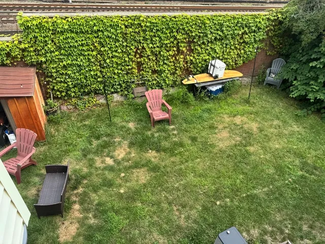 a backyard of a house with table and chairs