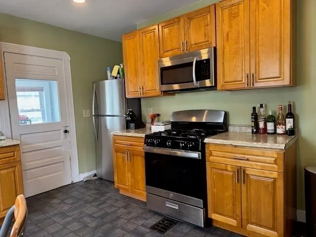 a kitchen with stainless steel appliances granite countertop a stove microwave and refrigerator