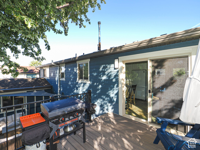 3308 Willow Ridge Road Salt Lake City, UT 84121 - Photo 15 of 59 Deck with wood-finish flooring, black metal railing, blue exterior siding, and sliding glass door