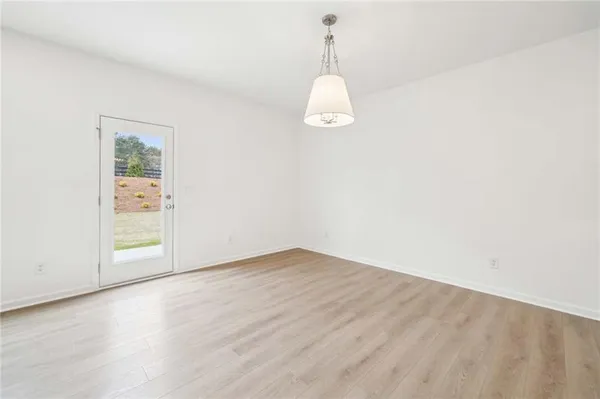 a view of a room with wooden floor and white walls