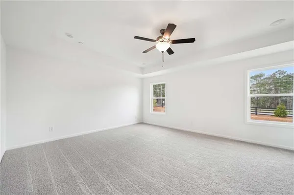 an empty room with a window and a ceiling fan
