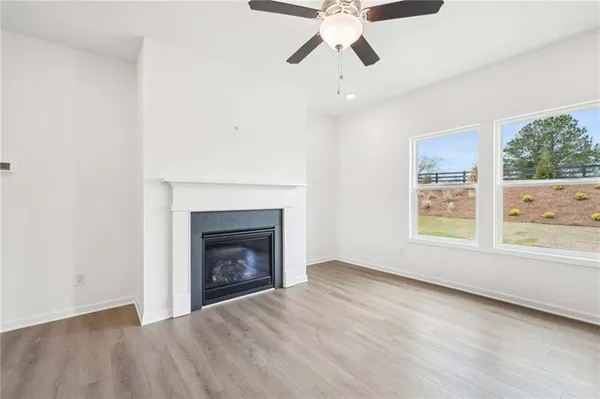 an empty room with windows and fireplace