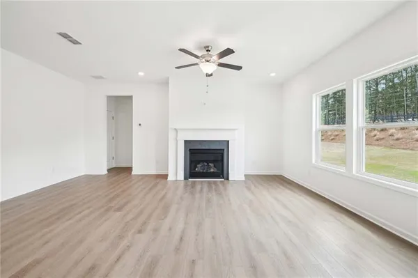 a view of an empty room with a window and a fireplace